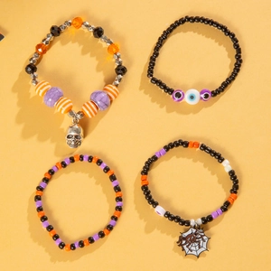 Detailed close-up of a four-piece Halloween beaded bracelet set with skull and evil eye charms
