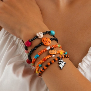 Close-up of five Halloween beaded bracelets featuring skull, pumpkin, and ghost charms