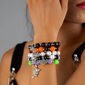 Detail of multilayer Halloween beaded bracelets with skull, pumpkin and bat charms
