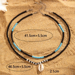 Détail du collier à deux rangs avec pendentif en coquillage et perles style plage bohème