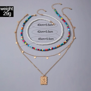 Détail d'un collier multicouche avec perles, perles colorées et pendentif fleur de rose