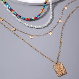 Détail d'un collier multicouche bohème avec perles colorées et pendentif rose dorée