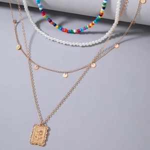 Détail du collier bohème multi-rangs avec perles colorées et médaillons dorés fins