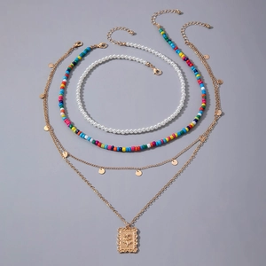 Détail d'un ensemble de quatre colliers bohèmes avec perles colorées et pendentif fleur