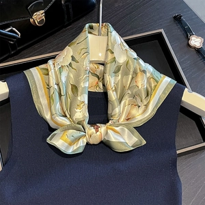 Elegant silk scarf with lily prints and bow tie knot on a white hanger display