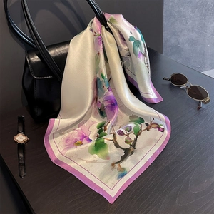 53cm floral silk scarf with elegant magnolia print and purple borders on wood