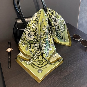 Detail eines Seiden-Seidenschals an einer Handtasche mit elegantem Retro-Blumenmuster