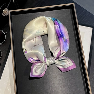 Floral silk square scarf in cream with elegant botanical print on a display tray
