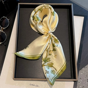 Detailansicht eines Seidenschals mit Blumenmuster und eleganter Perlenschnalle