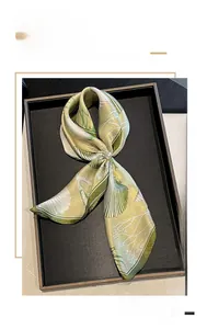 Detail of silk square scarf with seashell patterns and decorative pearl center piece