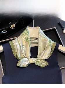 Detail of 100% mulberry silk scarf with champagne gold ocean print and green hand-rolled edge