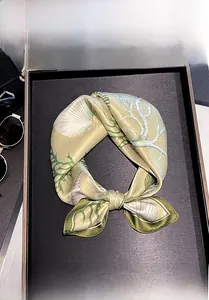 Close-up of 100% mulberry silk scarf featuring golden shells and coral nautical patterns