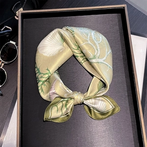 Detail of silk scarf showing marine patterns like shells and corals in green and cream