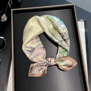 Elegant floral silk scarf with pink blooms on yellow satin displayed in a gift tray