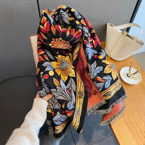 Close-up of fringe trim on black jacquard scarf with vibrant sunflower floral embroidery