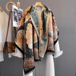 Detail of oil painting floral jacquard scarf with artistic fringe on a white coat