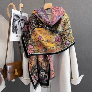 Detail view of abstract floral jacquard scarf with fine fringe on wool coat