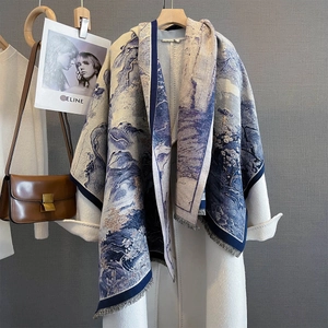 Close-up of blue floral jacquard scarf with tassels on a white wool coat