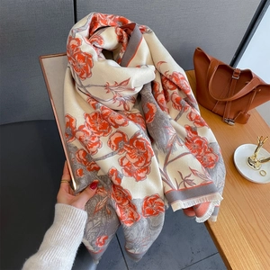 Détail de l'écharpe en jacquard floral avec motifs orange vintage et bords à franges