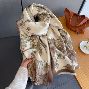 Écharpe vintage à fleurs en cachemire avec pompons sur une table en bois