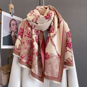 Détail du motif floral vintage sur écharpe crème aspect cachemire avec bords à franges