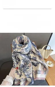Detail of floral imitation cashmere scarf with blue trees and pink fringe edges