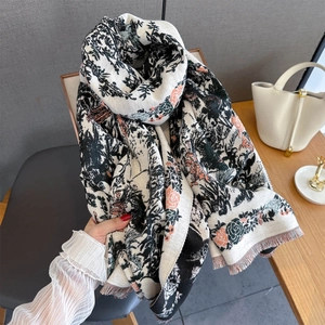 Close-up of vintage floral bird print pashmina scarf with orange flowers and fringe trim