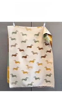 Détail du motif jacquard teckel sur une écharpe d'hiver beige doux avec franges