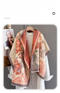 Detailed view of imitation cashmere scarf with orange floral pattern and soft fringe