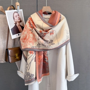Detailed texture of thick floral jacquard shawl with fringes on white coat