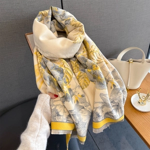 Close-up of cashmere-like scarf with yellow floral jacquard and delicate fringe