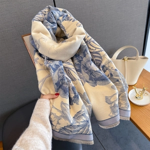 Detail of blue floral cashmere scarf with delicate fringe edges and soft drape texture