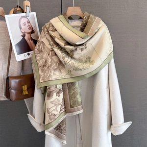 Close-up of vintage floral pashmina scarf with fringe details on a wool coat