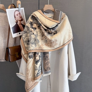 Detailed view of floral imitation cashmere scarf with tassels on a white coat