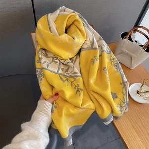 Close-up of yellow floral scarf showing soft cashmere-like texture and frayed edges