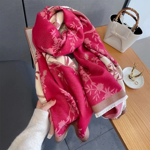 Detail of red floral jacquard scarf with fringe trim and premium fabric texture