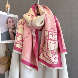 Detail of floral print scarf texture and delicate fringe trim on wool blend pashmina