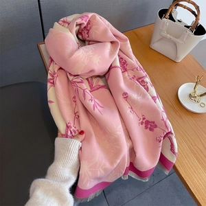 Detail shot of soft floral knit scarf featuring pink jacquard patterns and fine tassels