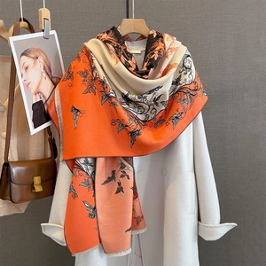 Dettaglio di farfalle e fiori su grande scialle pashmina arancione e beige