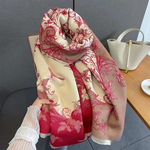 Dettaglio della sciarpa jacquard con motivi floreali e frange in rosso e beige