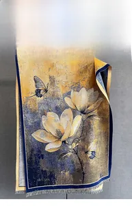 Détail de l'écharpe jaune et marine avec motifs de magnolia et finitions à franges