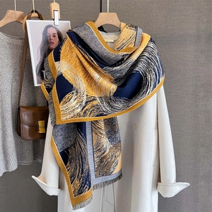 Thick cashmere-like scarf with blue and yellow swirl print and tassel edges