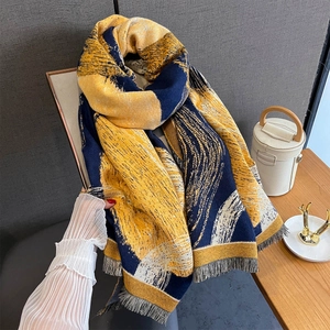 Macro view of thick faux cashmere scarf with navy and yellow abstract print and fringe