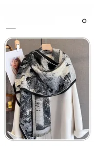 Dettaglio sciarpa in finto cashmere con stampa astratta in bianco e nero e finitura frangiata