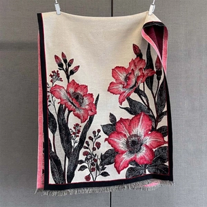 Vue détaillée d'une écharpe à fleurs avec motifs de lys rouges et franges