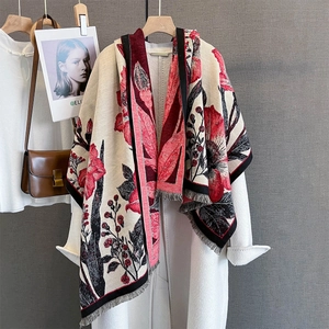 Châle en tricot élégant avec fleurs rouges et détails de glands sur manteau blanc