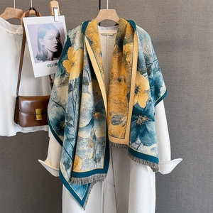 Sciarpa floreale in finto cashmere giallo e verde acqua su un cappotto di lana bianco