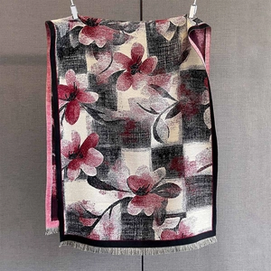 Détail d'une écharpe fleurie d'automne à damier avec de délicates franges grises
