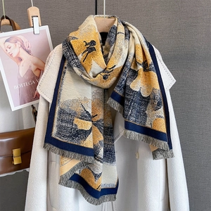 Vue détaillée d'un châle en tricot floral avec franges sur un long manteau en laine