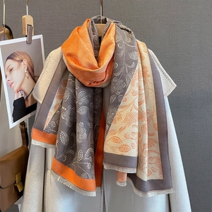 Detailed close-up of color-block scarf with botanical paisley print and fringe edges